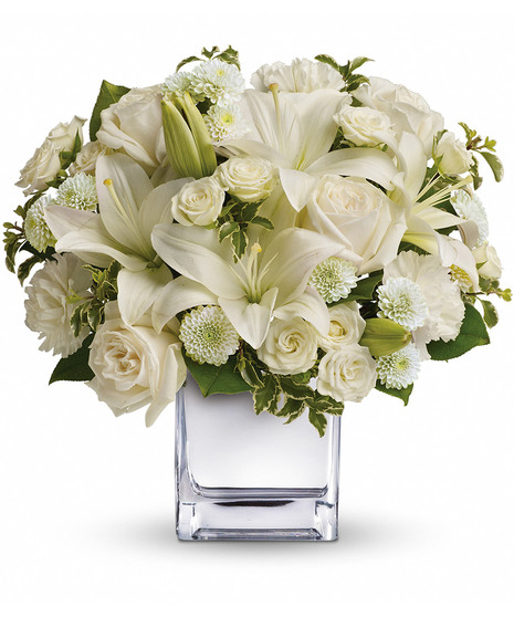 White roses, lilies and other favorites are displayed in a chic mirrored silver cube.
